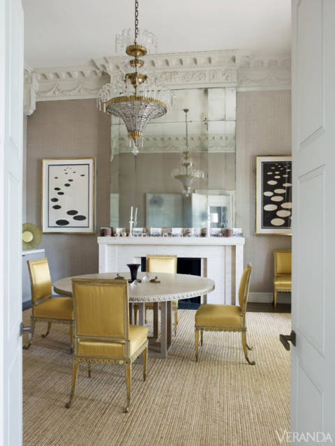 For the living and dining rooms, Grenney designed stunning travertine fireplace surrounds that allude to the period. Above them, his tall, antiqued mirrored panels also nod to the past, as do the soaring fifteen-foot ceilings.
Chairs, Cove Landing, in Claremont silk. Jansen chandelier. Mantel and linen on walls, both custom. Art, Alexander Calder.
